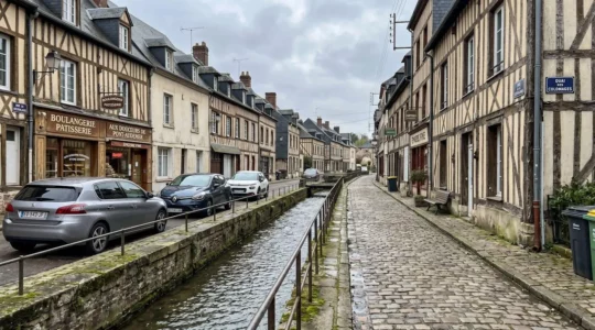 Rue de Pont-Audemer avec maisons à colombages traditionnelles et canal traversant le quartier historique