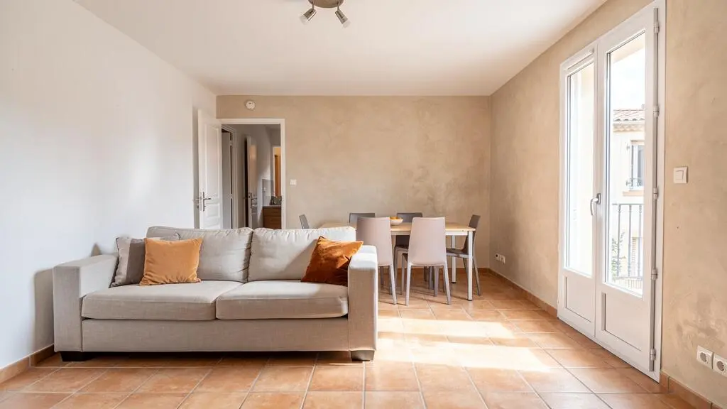 Intérieur lumineux d'un appartement type en location à Narbonne avec salon et espace de vie